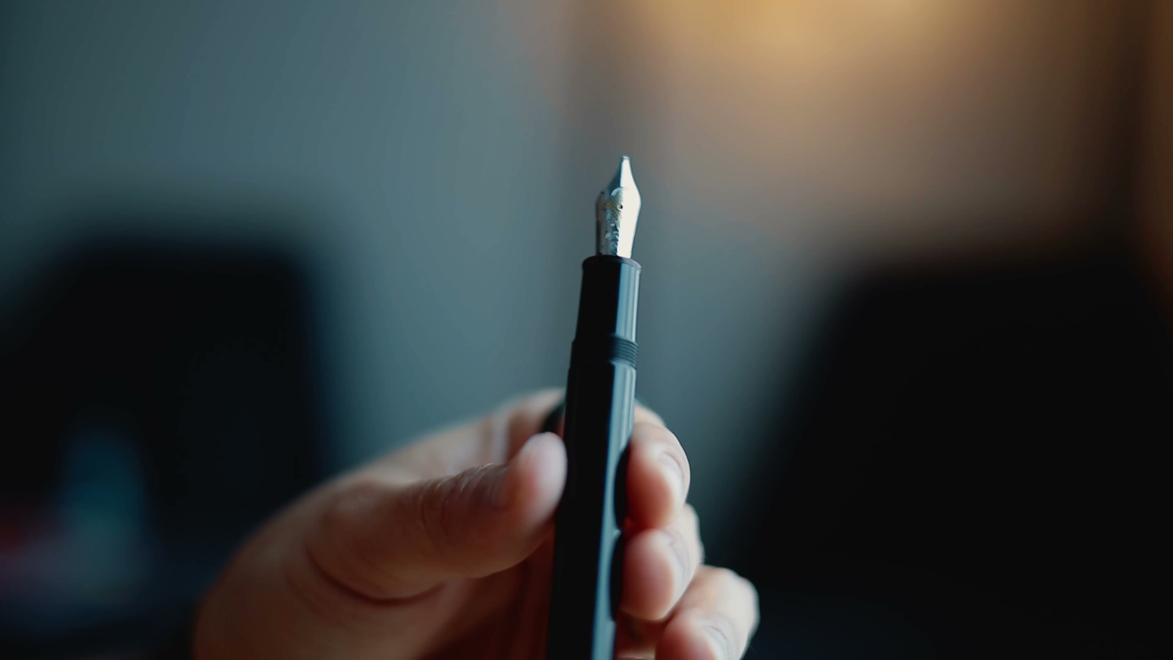 A fountain pen held over an open notebook page
